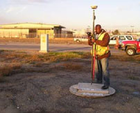 A surveyor using a survey tool on the side of the road