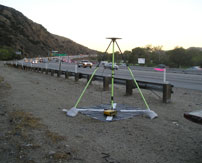 Tripod survey tool on the side of a freeway